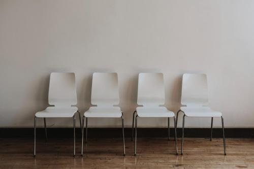 four-empty-white-chairs-room